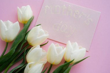 Zarfın en üstünde anneler günü resmi var. Pembe üzerinde açan çiçeklerin yanında. 