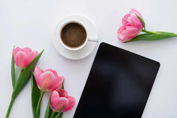 Widok Góry Filiżanki Kawy Pobliżu Różowych Tulipanów Tabletki Cyfrowej Pustym — Zdjęcie stockowe