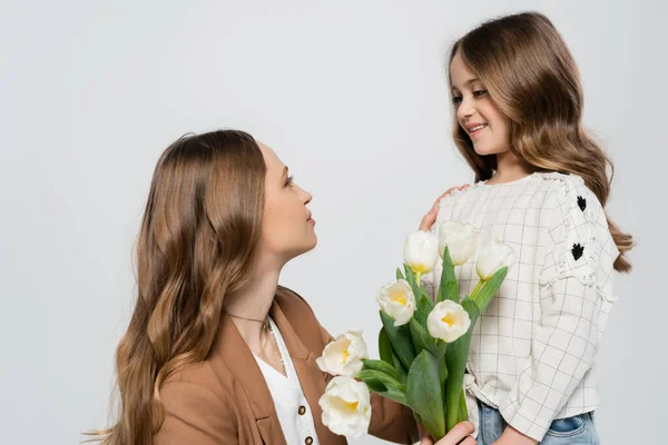 Frau Schaut Lächelnde Tochter Während Sie Tulpen Auf Grau Isoliert — Stockfoto