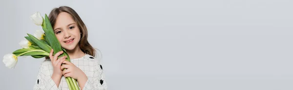 Усміхнена Дівчина Тримає Білі Тюльпани Біля Обличчя Ізольовані Сірому Банер — стокове фото