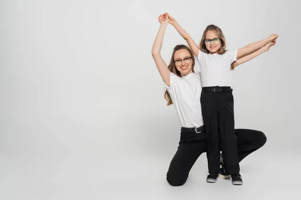 Upphetsad Flicka Med Mamma Hålla Händer Och Titta Kameran Samtidigt — Stockfoto