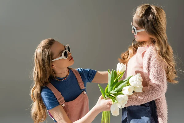 Matka Okularach Przeciwsłonecznych Otrzymuje Kwiaty Szczęśliwej Córki Odizolowanej Szaro — Zdjęcie stockowe