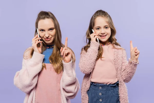 Szczęśliwa Matka Córka Rozmawiają Przez Telefon Komórkowy Wskazują Odizolowany Fioletowy — Zdjęcie stockowe