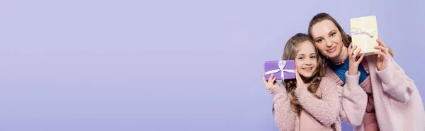 幸せな子供と陽気な母親が紫色のバナーに孤立したプレゼントを持っている — ストック写真