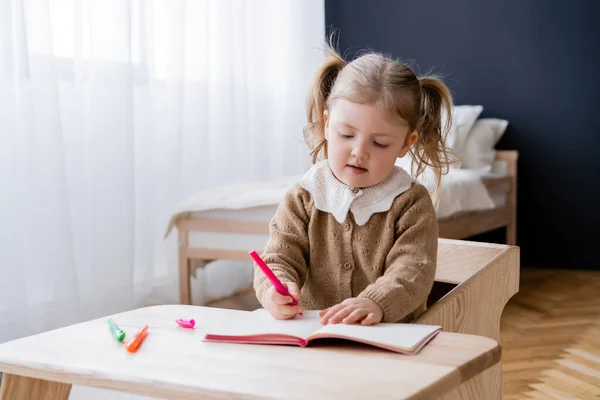 Kleines Mädchen Zeichnet Mit Bunten Filzstiften Während Tisch Schlafzimmer Sitzt — Stockfoto