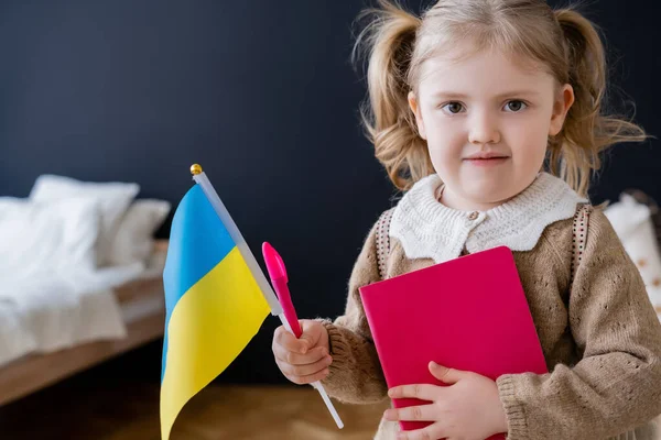 Patriotisches Mädchen Mit Buch Und Kleiner Ukrainischer Fahne Während Hause — Stockfoto