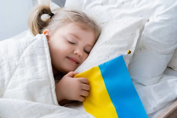 Счастливая Девушка Улыбающаяся Время Сна Постели Маленьким Украинским Флагом — стоковое фото