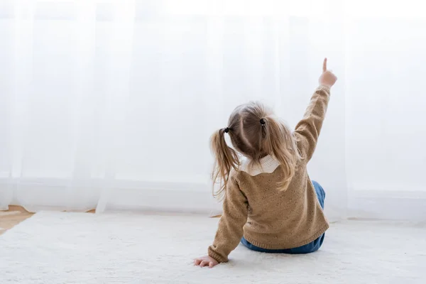 Вид Ззаду Маленької Дівчинки Хвостами Вказують Пальцем Сидячи Підлозі Вдома — стокове фото