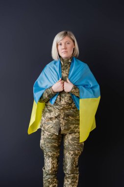 Siyah omuzlarında Ukrayna bayrağı olan askeri kadının ön görüntüsü
