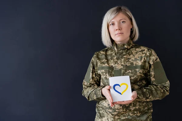 Mujer Militar Rubia Mirando Cámara Mientras Sostiene Tarjeta Con Corazón — Foto de Stock