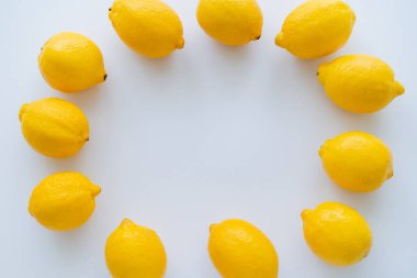 Beyaz arkaplanda yuvarlak şekilli limonların üst görünümü 