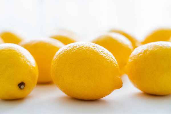 Close up view of fresh lemons with light on white background 
