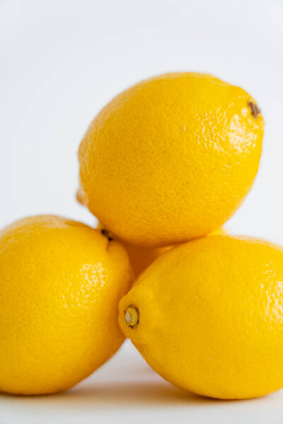 Close up view of blurred yellow lemons on white background 