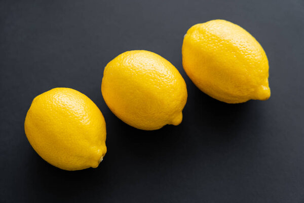 Top view of ripe lemons on black background 