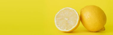 Close up view of juicy half and whole lemon on yellow background, banner  clipart
