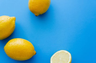 Top view of fresh lemons on blue background with copy space 