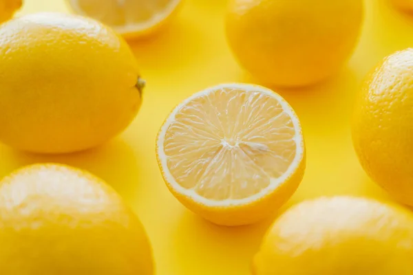 Close View Cut Blurred Whole Lemons Yellow Surface — Stock Photo, Image