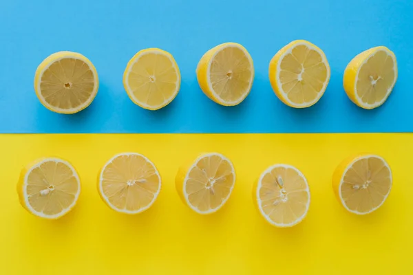 Vista Superior Mitades Maduras Limones Sobre Fondo Azul Amarillo — Foto de Stock