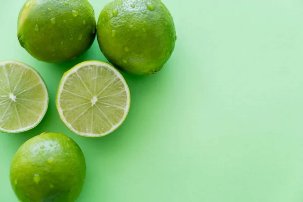 Top View Organic Limes Water Drops Green Background Copy Space — Foto Stock