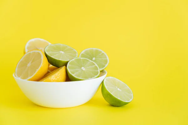 Mitades Frescas Limas Limones Tazón Sobre Fondo Amarillo — Foto de Stock