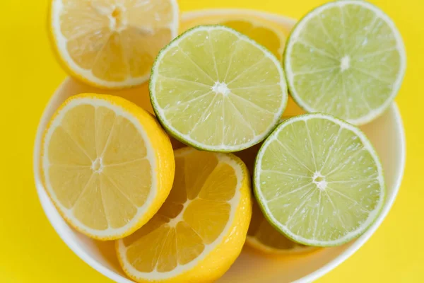 Top View Fresh Lemons Limes Bowl Yellow Background — Stok fotoğraf