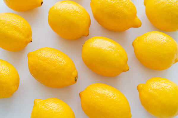 Flat lay of bright lemons on white background 