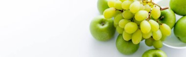 top view of green and ripe apples near grapes on white, banner