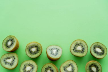 flat lay of fresh kiwi fruit halves on green