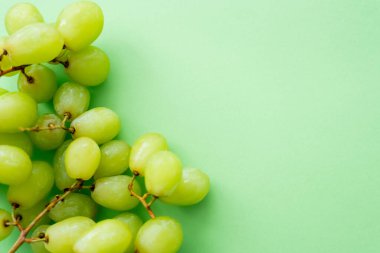 top view of ripe and organic grapes on green clipart