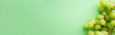 top view of ripe and organic grapes on green, banner
