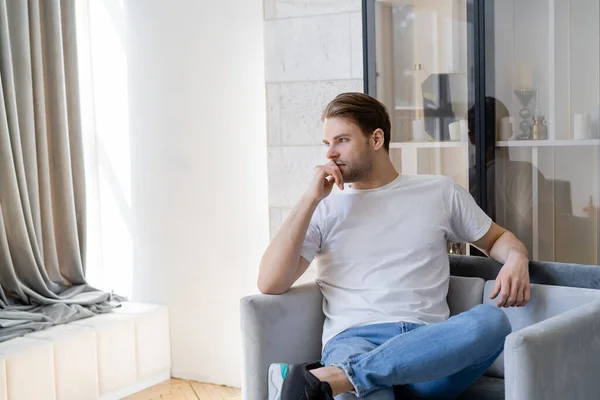 Nachdenklicher Mann Weißen Shirt Sitzt Sessel Und Schaut Weg — Stockfoto