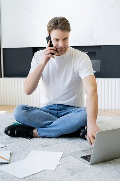 Young Man Sitting Floor Crossed Legs Talking Smartphone Laptop — Stock Photo, Image