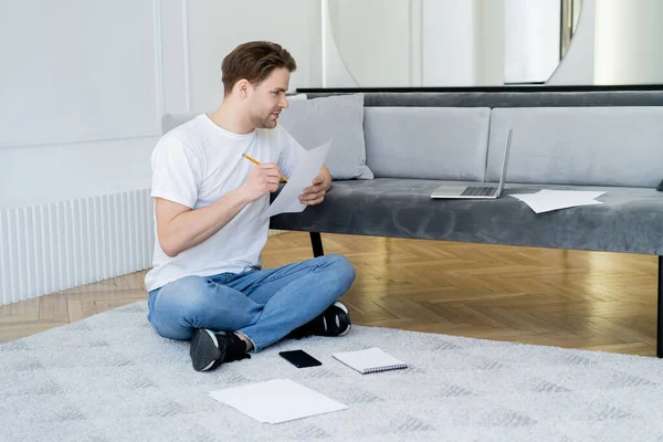 Hombre Mirando Computadora Portátil Mientras Está Sentado Suelo Con Papel — Foto de Stock