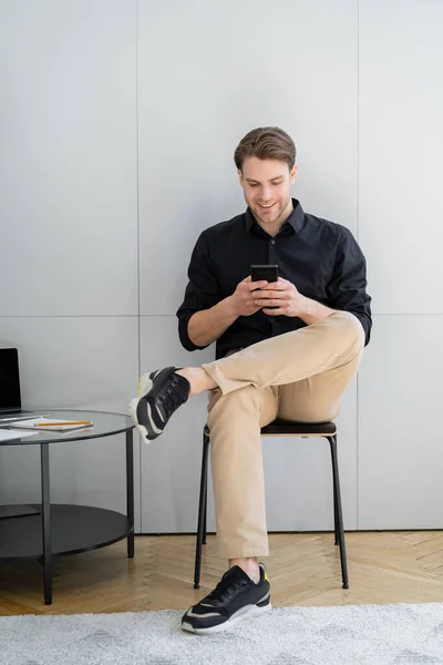 Happy Man Chatting Smartphone While Sitting Grey Wall Home — Stock Photo, Image