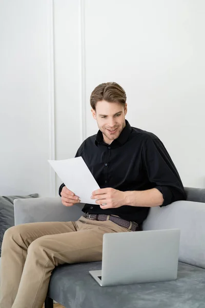 Smiling Man Document Sitting Couch Looking Laptop — Stock Photo, Image