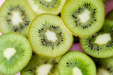 top view of sliced fresh kiwi on pink, close up