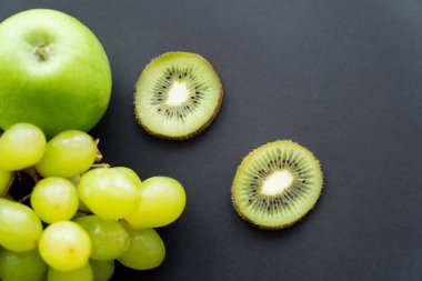 top view of green and tasty fruits on black 
