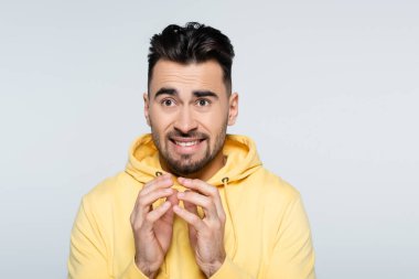 Endişeli kumarbaz sarı kapüşonlu jest gri üzerine izole