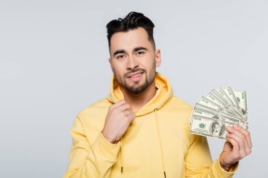 bookmaker with dollar banknotes smiling at camera isolated on grey
