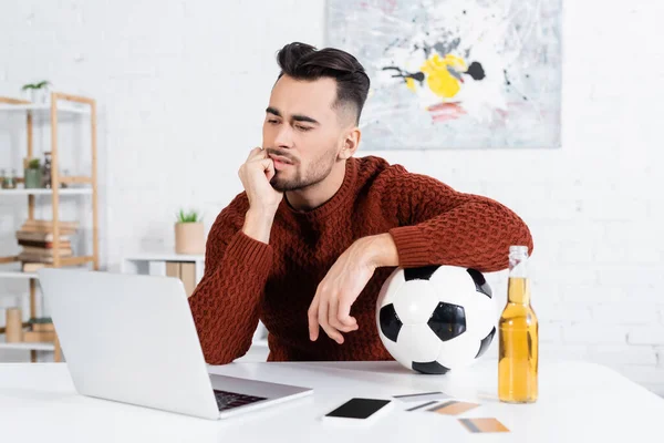 Thoughtful Bookmaker Soccer Ball Looking Laptop Smartphone Credit Cards — Stockfoto