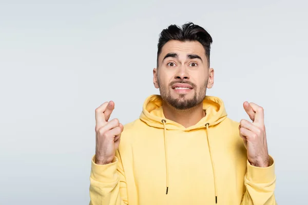 Worried Gambler Yellow Hoodie Holding Crossed Fingers Luck Isolated Grey — Stock Photo, Image