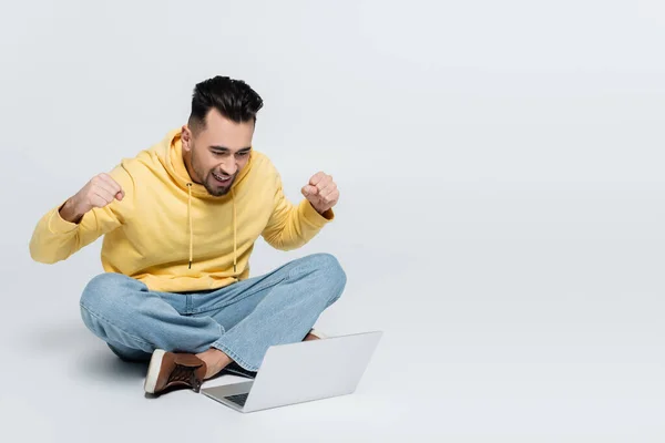 Cheerful Man Showing Triumph Gesture While Sitting Laptop Grey — Stockfoto