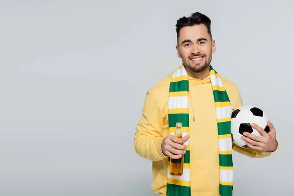 sports fan with soccer ball and beer smiling at camera isolated on grey
