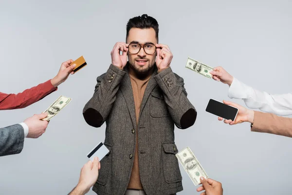 Young Critic Adjusting Eyeglasses People Credit Cards Dollars Cellphone Isolated — Stock Photo, Image