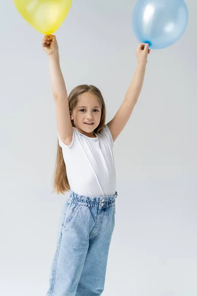 Menina Sorridente Shirt Branca Segurando Balões Azuis Amarelos Mãos Levantadas — Fotografia de Stock