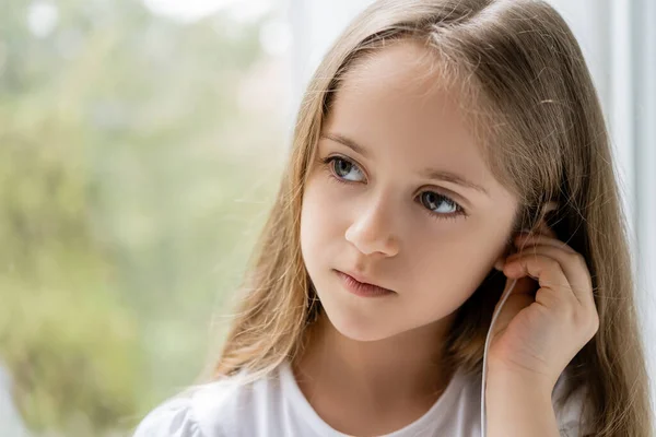 Κορίτσι Μακριά Μαλλιά Προσαρμογή Ακουστικό Κοντά Θολό Παράθυρο — Φωτογραφία Αρχείου