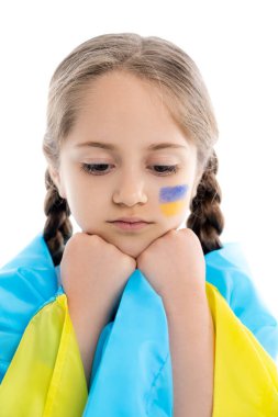 Ukrayna bayrağıyla kaplanmış hayal kırıklığına uğramış kız beyaz bir yüzün üzerinde el ele tutuşuyor.