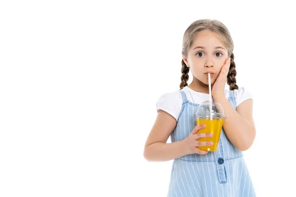 Asombrada Chica Tocando Cara Mientras Bebe Jugo Naranja Aislado Blanco — Foto de Stock