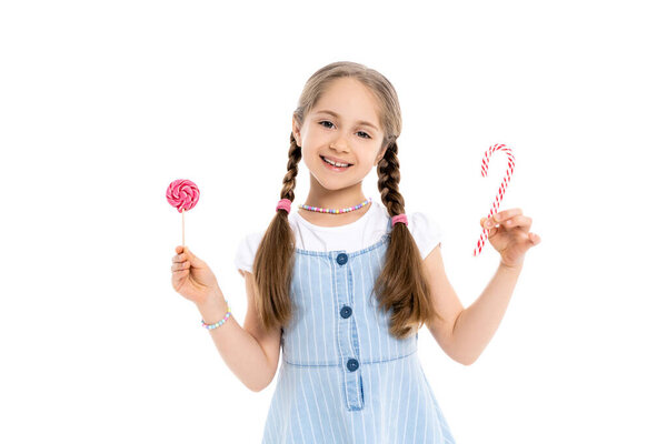 взволнованная девушка с конфеткой и леденец глядя на камеру изолированы на белом