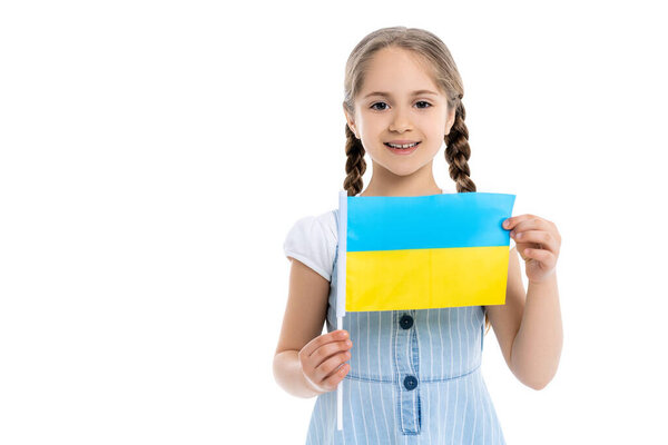 smiling girl with small ukrainian flag looking at camera isolated on white